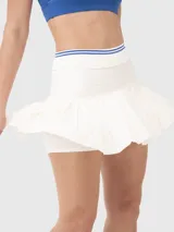 Falda blanca plisada con pretina elástica con detalles de líneas de color y calza incorporada con bolsillo. Ideal para tenis o pádel.