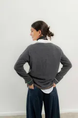 Sweater de punto gris con cuello en V y ribetes en contraste.