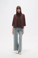 Polera holgada de poliéster color verde militar, con cuello alto tipo tortuga y mangas tres cuartos.