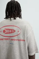 Camiseta gris de punto con cuello redondo y manga corta. Estampado combinado a contraste en delantero y espalda con la frase "Planetary Connection" y un diseño abstracto en rojo.