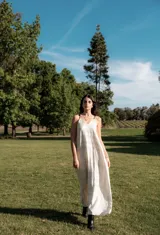 Vestido largo color crema con estampado geométrico lineal en negro, escote en V, breteles finos ajustables y bolsillos laterales.