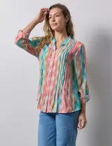 Blusa de gasa estampada multicolor, marca Ruby Rd. Tiene cuello a la base, escote en V, abertura central con botones y plisados en la parte delantera. Las mangas son 3/4 y tienen un largo regulable con presilla y botón.