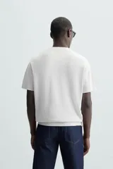 Camiseta negra de corte recto y manga corta, tejida en punto perlado de algodón.
