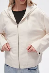 Campera color crudo de lino con capucha, cierre frontal y bolsillos plaqué.