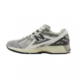 Championes urbanos New Balance modelo U1906NA, color gris y blanco, confeccionados en malla y materiales sintéticos, con logo "N" característico en los laterales y entresuela con tecnología ABZORB y N-ergy.