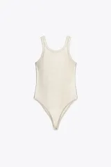 Body color crema de cuello redondo y sisas amplias. Tejido en rib metalizado con cierre inferior con broches a presión.