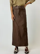 Falda midi color plateado metalizado, de corte recto con tajo en la espalda. Presenta detalles de costura que simulan bolsillos traseros.