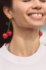 Aros colgantes con forma de cerezas rojas y tallo de cuentas verdes.