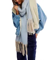 Bufanda manta de tejido suave, color blanco hueso, con flecos definidos en los bordes.