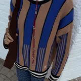 Sweater de punto oversize a rayas verticales rosas y bordó, con cuello alto y puños con ribete celeste.