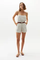 Short de lino 100% orgánico color natural, de cintura alta con tablas que le dan un calce holgado. Posee bolsillos laterales y cierre frontal con gancho metálico.