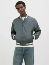 Campera bomber gris con cuello tipo baseball y puños de canalé. Cierre con botones y bolsillos frontales.