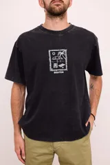 Remera negra con efecto gastado, corte amplio y estampado blanco en el pecho con motivos playeros.