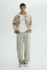 Remera blanca de corte holgado con cuello redondo y estampado con la frase "NOT A GOOD LISTENER" en letras negras.