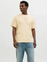 Remera color crema de algodón con cuello redondo, manga corta y estampado en la espalda con un paisaje costero.