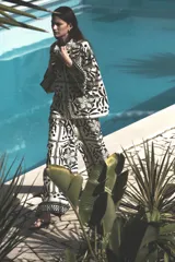Pantalón de tiro alto con elástico revestido y cordón para ajustar fino en la cintura. Piernas amplias de corte holgado con estampado de flores y figuras geométricas en blanco y negro.