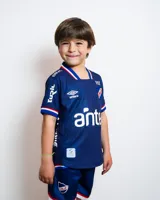 Camiseta de fútbol Umbro del Club Nacional de Football, modelo Away 2. Diseño azul con detalles en blanco y rojo. Incluye logo de Umbro, escudo del club y sponsor Antel en el frente.