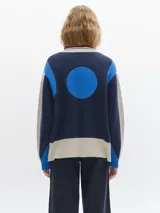Campera tejida con cierre delantero, bordado en la espalda, de color rojo con detalles marrones y grises.