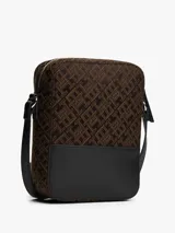 Cartera bandolera Tommy Hilfiger, color marrón con monograma de la marca en jacquard y base de cuero sintético negro. Tiene correa ajustable, compartimento principal con cierre y bolsillo externo con cierre.