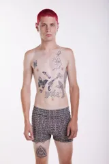 Short tipo boxer de tela elastizada con estampado geométrico en tonos beige y marrón.