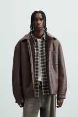 Sobrecamisa marrón de efecto piel con interior de borreguillo a tono, de corte relaxed fit, cuello solapa, manga larga con puños abotonados, bolsillos de plastrón en pecho y laterales, efecto lavado y cierre frontal con botones a presión.