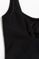 Traje de baño enterizo negro con breteles anchos, escote cuadrado y copas con relleno extraíble.
