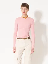 Remera rosa de punto con textura suave, mangas largas, escote redondo y espalda amplia y abierta.