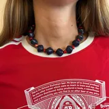 Collar corto con cuentas grandes de color azul marino alternadas con cuentas pequeñas de color rojo.