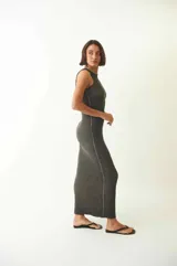 Vestido largo gris oscuro, ajustado al cuerpo, sin mangas y con cuello redondo. Confeccionado en tejido de morley con leve efecto desgastado.