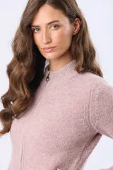 Campera tejida de abrigo color beige, con cierre frontal, cuello alto y bolsillos laterales.