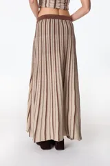 Falda midi tejida a rayas verticales en tonos celeste y azul, con cintura elástica y abertura lateral.