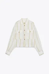 Camisa blanca a rayas verticales color beige, de corte recto, con cuello solapa, manga larga y dos bolsillos de parche en el pecho.