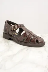 Sandalias cangrejeras de cuero marrón con textura croco, hebilla dorada y suela plana.