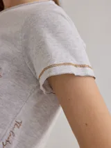 Remera color crudo de algodón, con bolsillo en el pecho y bordes con costuras a la vista.