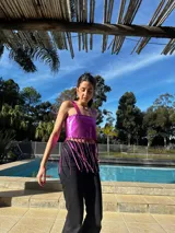 Top corto con breteles finos y flecos en el ruedo, confeccionado en cuero sintético.