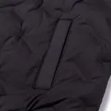 Chaleco negro acolchado con cierre frontal, bolsillos tipo welt y parche de silicona con el logo de Caterpillar en el pecho.