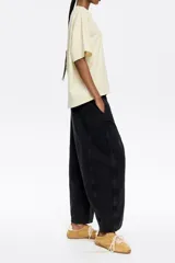 Pantalón vaquero de corte barrel, largo tobillero, tiro medio, con cierre frontal de botón y cremallera, bolsillos delanteros en costura, bolsillos de plastrón en la parte posterior y costadillos laterales.