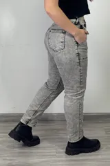 Pantalón de jean gris con efecto lavado, tiro alto, corte mom y bolsillos laterales.