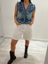 Bermuda marrón de gabardina elastizada con cinturón fino con tachas y detalles de flecos en el ruedo.