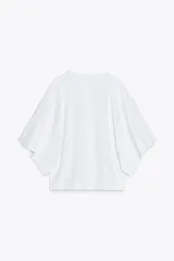 Camiseta blanca de algodón con cuello redondo y mangas cortas tipo capa.