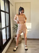 Short beige de tiro alto con cintura ajustable y detalles de costura blanca.