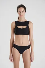 Bikini deportivo negro con recortes y superposiciones de tricot y powernet, diseño de bombacha de tiro bajo.