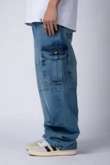 Pantalón jean azul de corte ancho, estilo cargo, con bolsillos laterales y detalles metálicos.