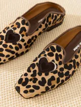 Mocasín mule de cuero con estampado animal print, capellada con recorte decorativo y aplique de corazón.