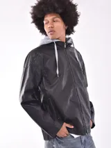 Campera negra de cuero sintético con capucha gris de algodón y cierre frontal.