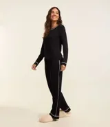 Conjunto de pijama largo negro confeccionado en viscosa. Incluye remera de mangas largas con cuello redondo y pantalón con cintura elástica. Ambas piezas tienen bordes contrastados en color blanco.