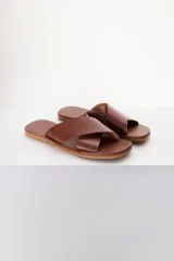 Sandalias bajas de cuero azul con tiras anchas cruzadas sobre el empeine y suela plana color madera.