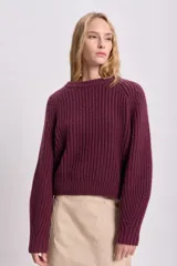 Sweater bordó de punto grueso con cuello redondo y mangas ranglan.