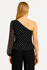 Blusa blanca asimétrica con un hombro descubierto, manga larga abullonada y estampado de lunares plateados.