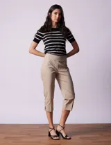 Pantalón capri color beige de gabardina elastizada, marca Ruby Rd. Delantera con bolsillos simulados, trasera con bolsillos aplicados. Pretina ancha, corte recto y terminación de ruedo con detalle calado.